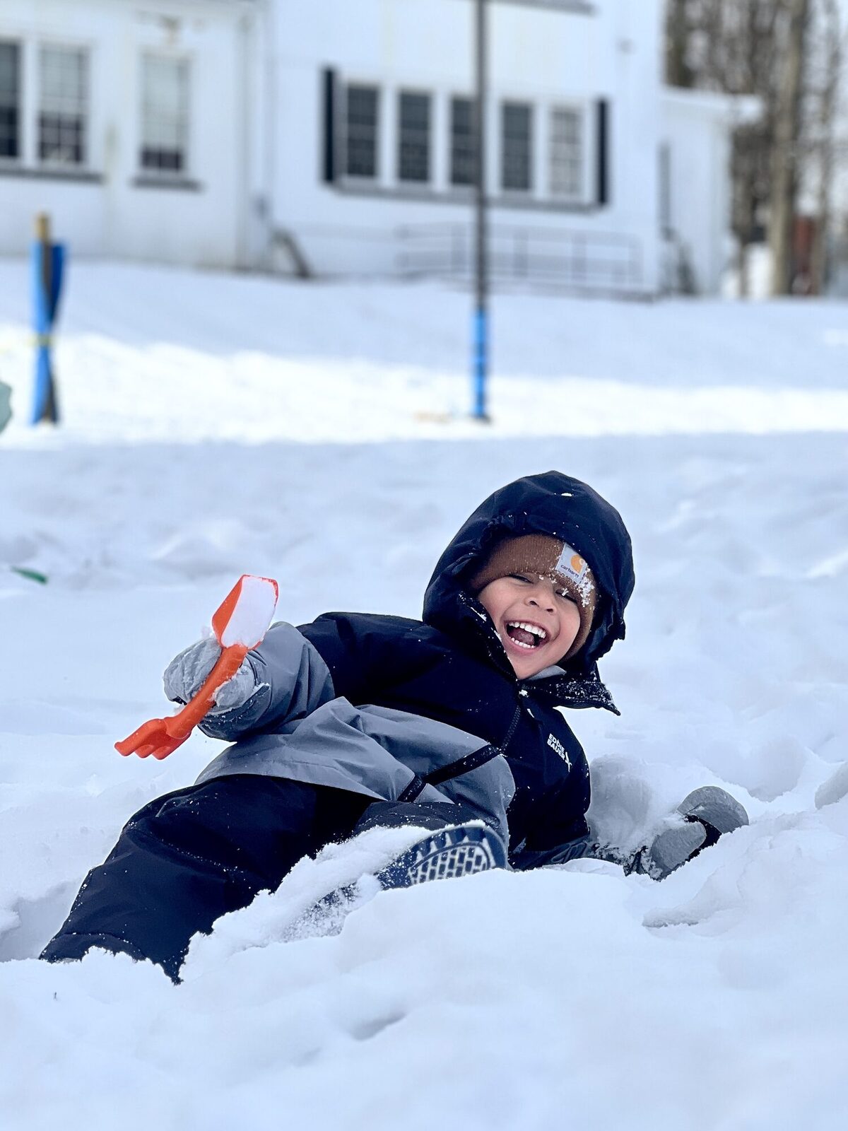 Preschooler laughing while playing in the snow